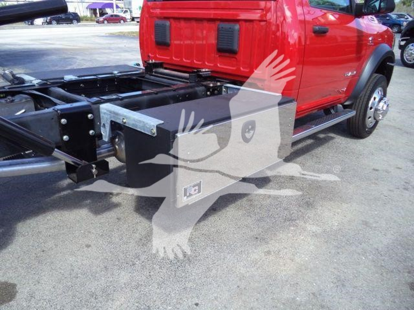 Ram 5500 chassis with rollback setup showing side view and partial cab; empty frame rails and hydraulic components visible.