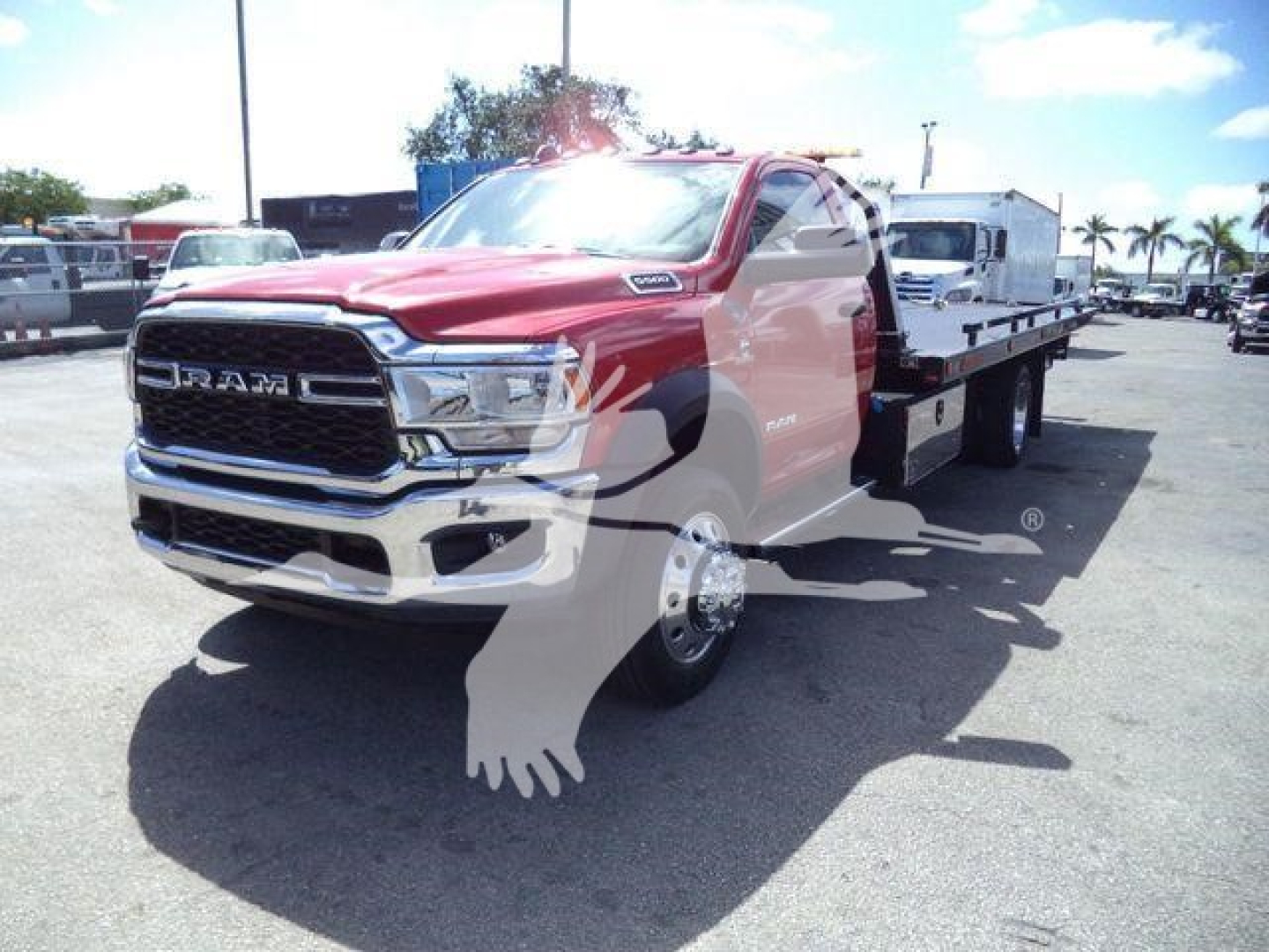 Ram 5500 rollback tow truck front-left view showing chrome grille and flatbed.