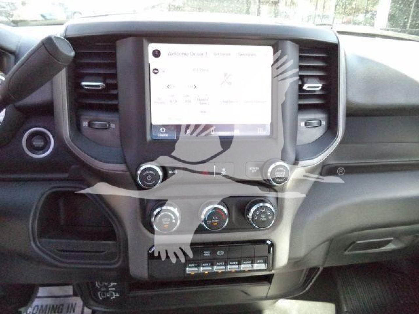 Interior view of a 2024 Ram 5500 SLT dash and center console, showing a large infotainment touchscreen, climate controls, and gear selector area.