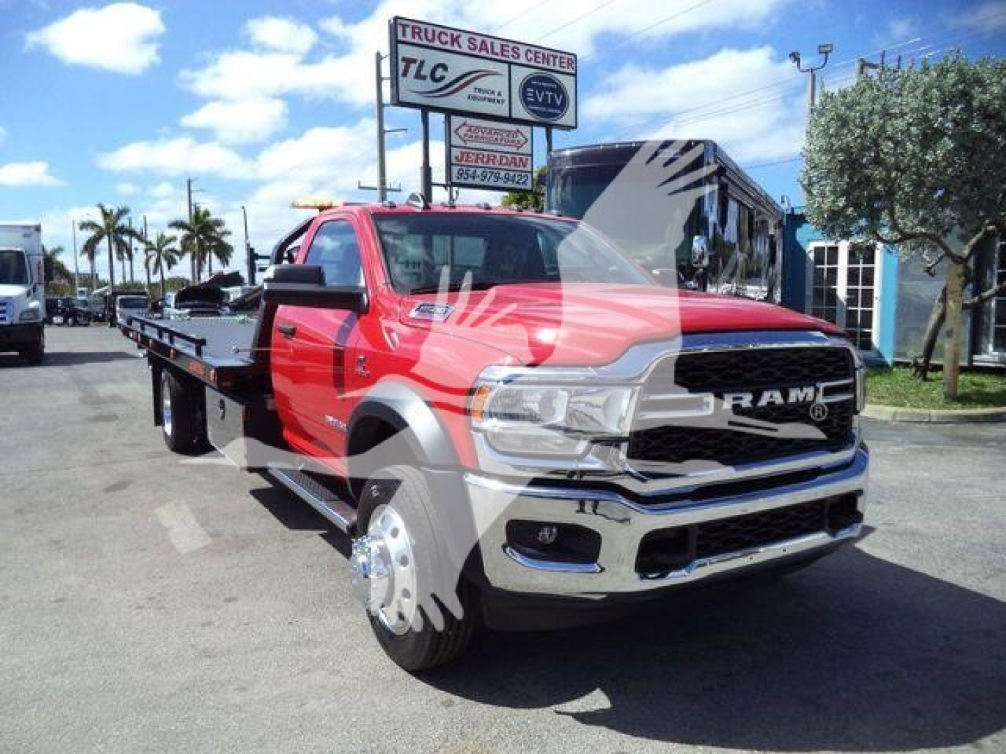 Ram 5500 SLT tow truck/rollback with red cab and flatbed shown front-left angle; front grille with RAM logo visible.