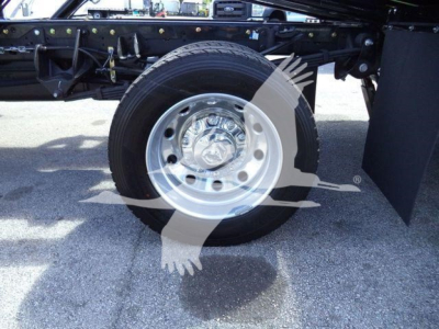 Ram 5500 front wheel and suspension view showing steel wheel and tire under truck frame.