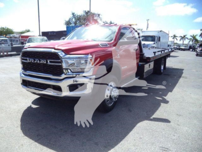 Ram 5500 rollback tow truck front-left view showing chrome grille and flatbed.