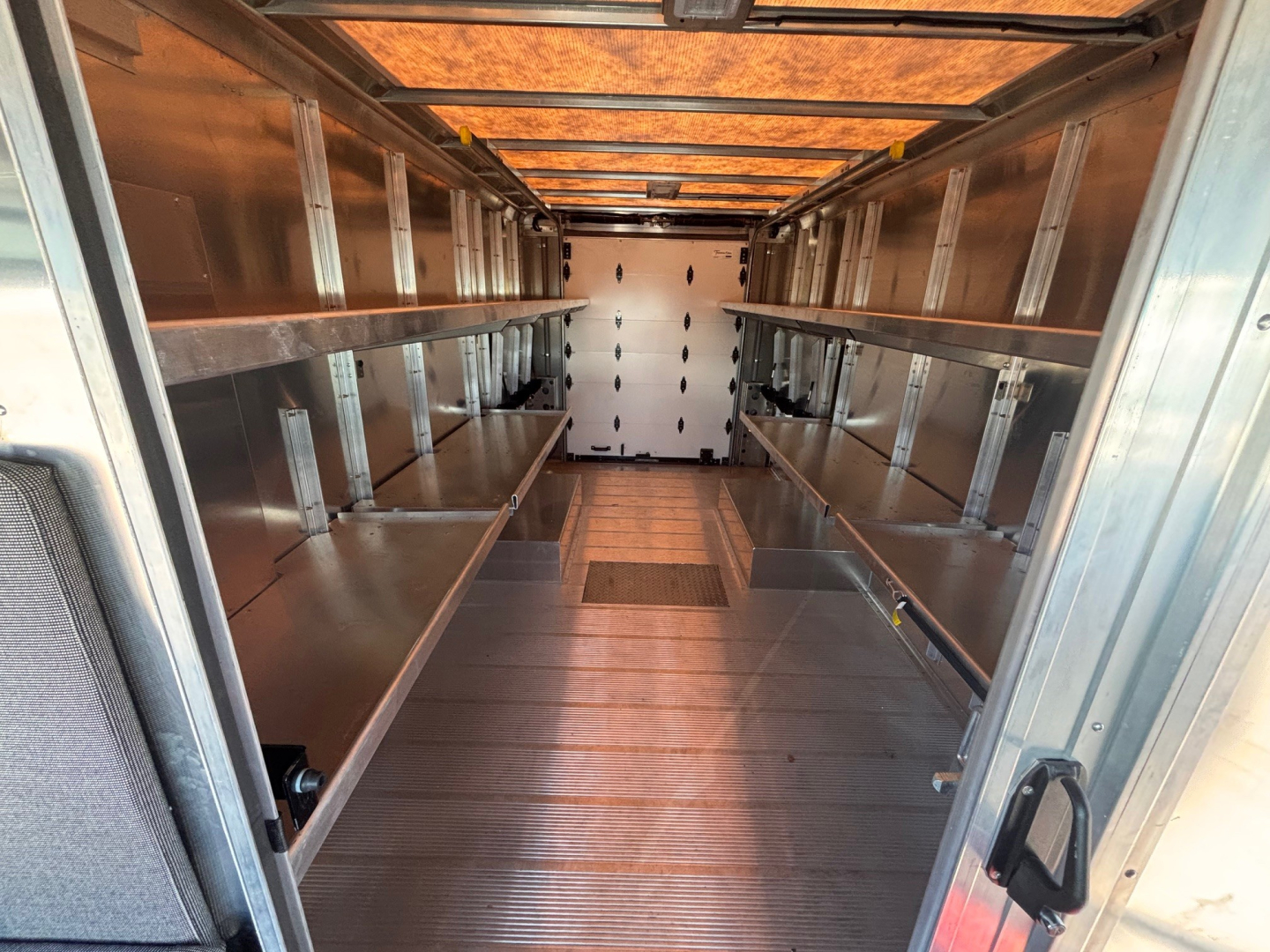 Harbinger S534 step van cargo interior showing metal shelving along both walls and aluminum flooring.