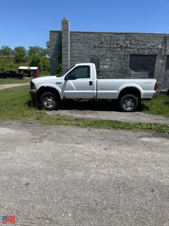 Ford F-350 pickup truck side view showing white cab and bed with 4x4 badge, in-service condition.