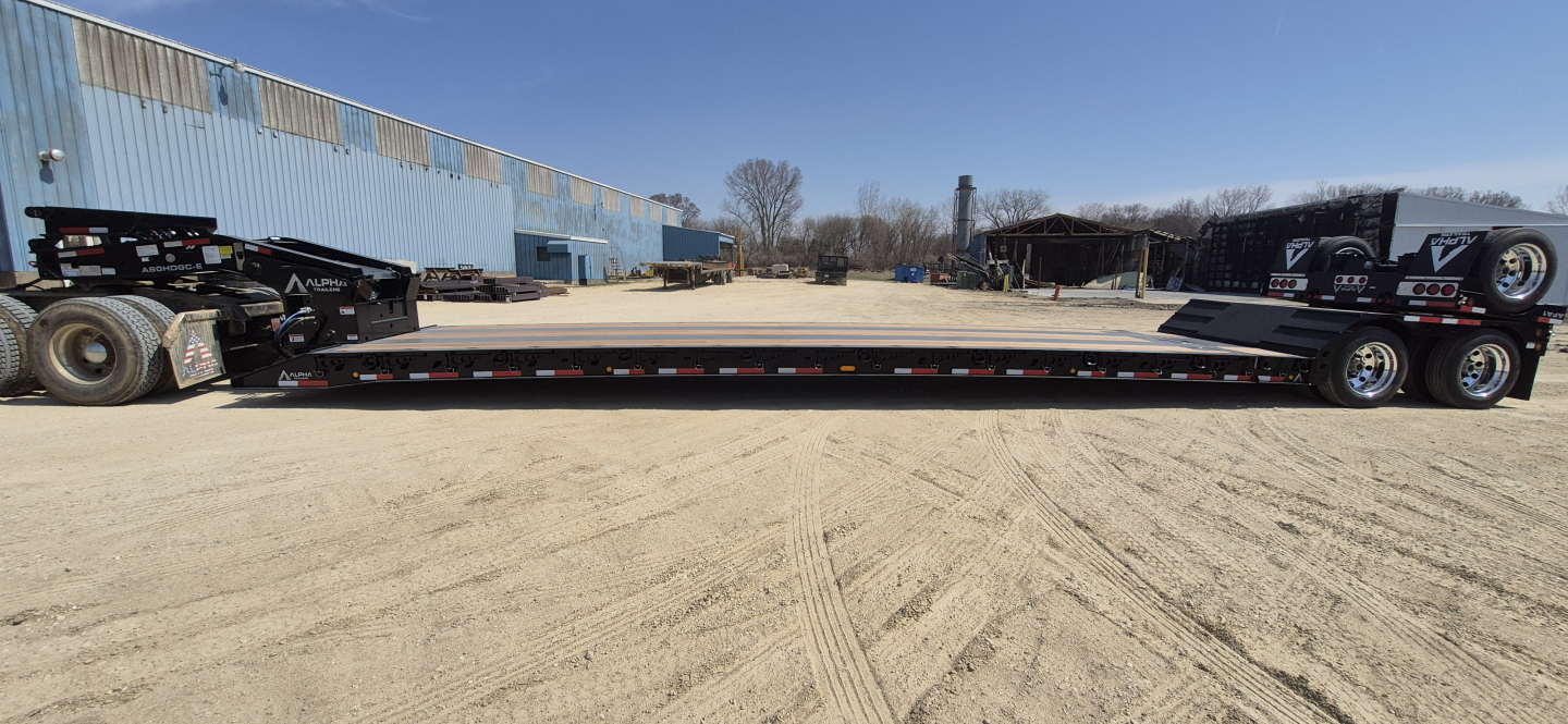 Lowboy trailer showing 48-foot extendable hyd_detach double drop with dual rear axles and extendable deck.
