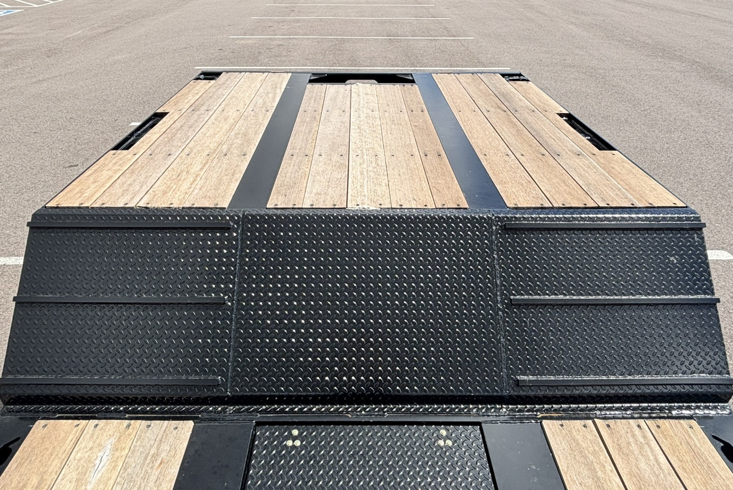 Lowboy trailer deck with wood planks and diamond plate steel, extendable hyd detach double drop, rear view showing deck and ramp sections.