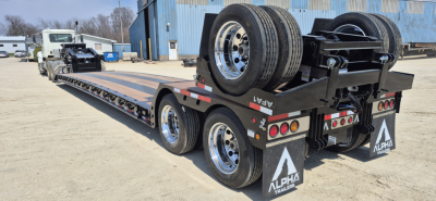 Alpha trailers HDGC-E lowboy showing extendable double drop with hydraulic detachment. Tandem rear axles, spare tires mounted on gooseneck area, rear mudflaps with Alpha logo.