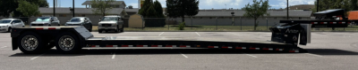 Lowboy trailer with extended hyd detach double drop extendable configuration showing long flat deck and rear hitch area.