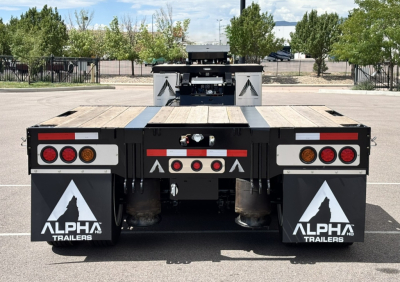 Rear view of Alpha Trailers 2027 A80 HDGC-E lowboy trailer with dual pneumatic mud flaps, taillights, and deck extension.