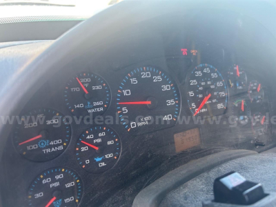 Instrument cluster in a truck showing gauges including tachometer, speedometer, fuel, oil, and water temp with warning indicators visible.