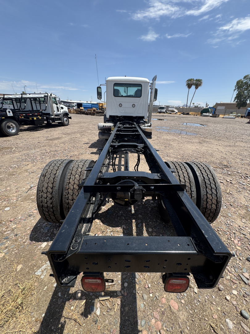 Back of a white Mack GR44B chassis showing dual rear axles and frame rails with taillights visible.
