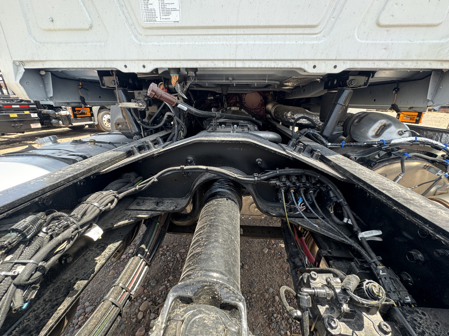 Chassis view shows drive shaft and undercarriage of a Mack GR44B cab and chassis with exposed drivetrain and hydraulic lines.