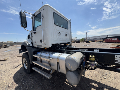 Truck cab and chassis showing side view with fuel tanks and steps, Mack GR44B truck cab, white exterior, chrome fuel tanks, dual rear frame rails, side-mounted air tanks and steps.