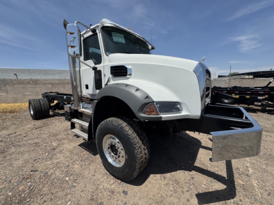 Mack GR44B cab and chassis truck side view showing front wheel, white hood, metal front bumper/dump chest area, and utility side mirror.