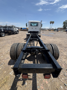 Back of a white Mack GR44B chassis showing dual rear axles and frame rails with taillights visible.