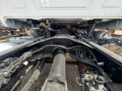Chassis view shows drive shaft and undercarriage of a Mack GR44B cab and chassis with exposed drivetrain and hydraulic lines.
