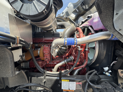 Mack GR44B engine bay showing turbocharger and coolant hoses with red engine block and various metal tubes.