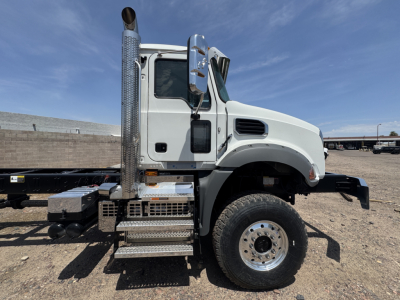 Truck cab and chassis side view showing metallic steps, vertical exhaust stack, and front wheel. Visible text on components not legible.