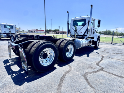 Tractor-trailer chassis of a 2027 Mack PI64T daycab truck showing rear tandem axles and chrome fuel tanks.