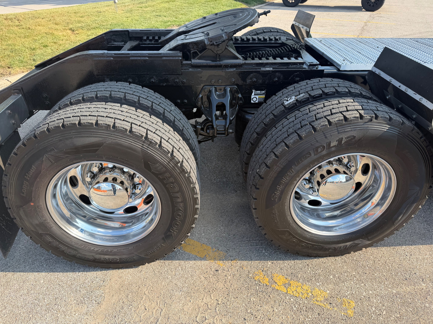 Peterbilt 389 tractor rear wheel area showing dual rear tires, chrome rims, and fifth-wheel hitch area.