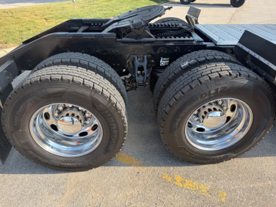 Peterbilt 389 tractor rear wheel area showing dual rear tires, chrome rims, and fifth-wheel hitch area.