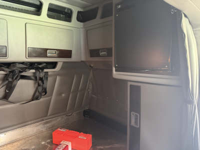 Peterbilt 389 sleeper cab interior showing storage compartments and a mounted screen on the right side.