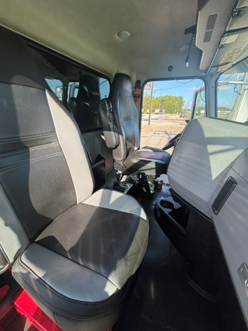 Truck cab interior view of a 2022 Mack GRANITE showing front seats, dashboard, and center console with light and dark upholstery.