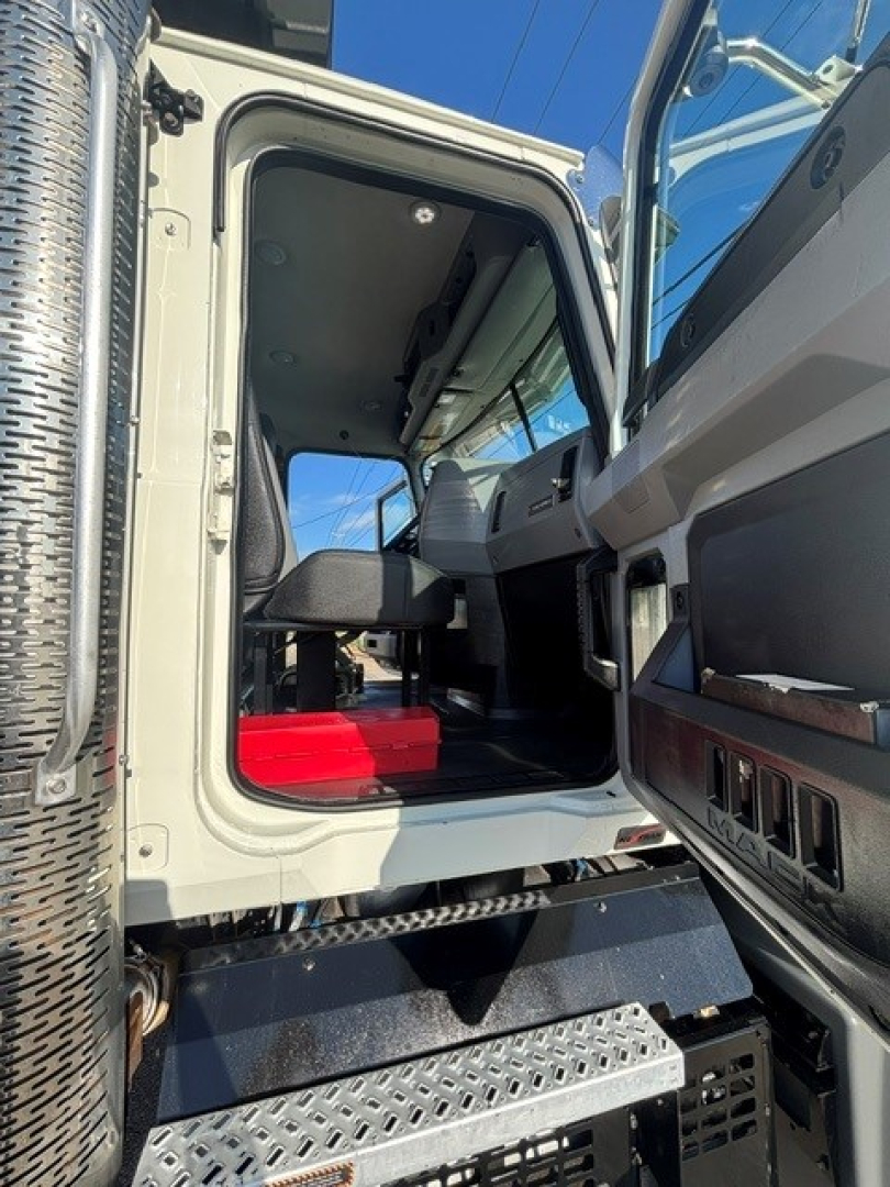 Mack Granite dump truck interior cab view with open door showing driver seat and dashboard