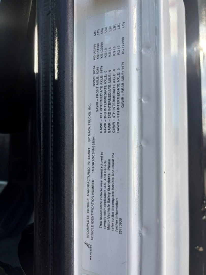 Label plate on Mack Granite truck showing various specification lines and VIN area, with printed small text.