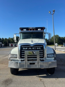 Front view of a white 2022 Mack Granite dump truck showing the Mack grille and bumper, with large mirrors and headlamps.