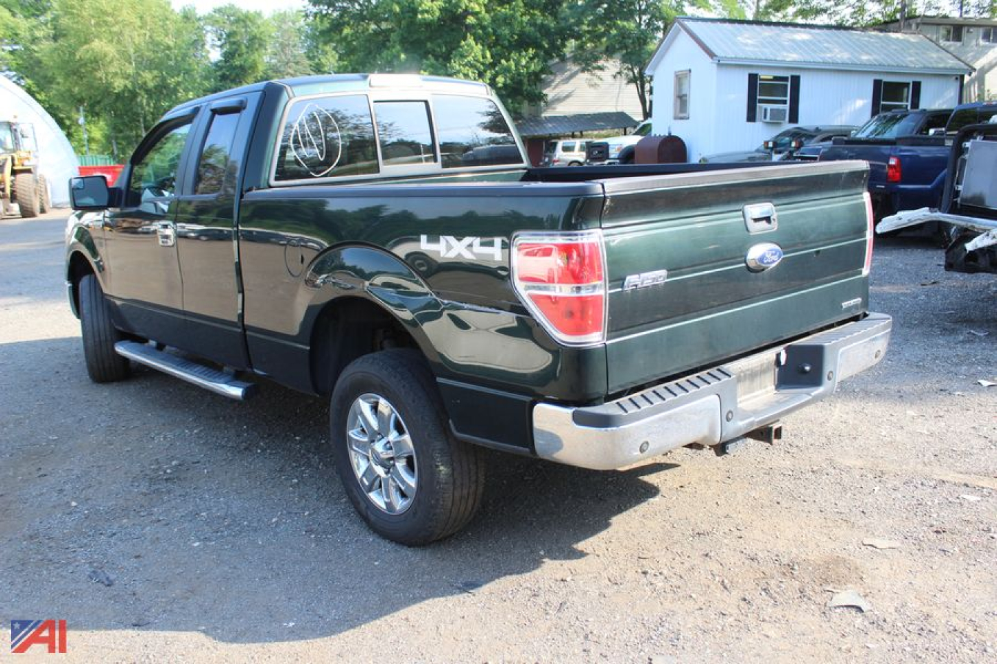 Ford F-150 pickup truck rear three-quarter view showing 4x4 badge and cargo bed, green with chrome bumper.