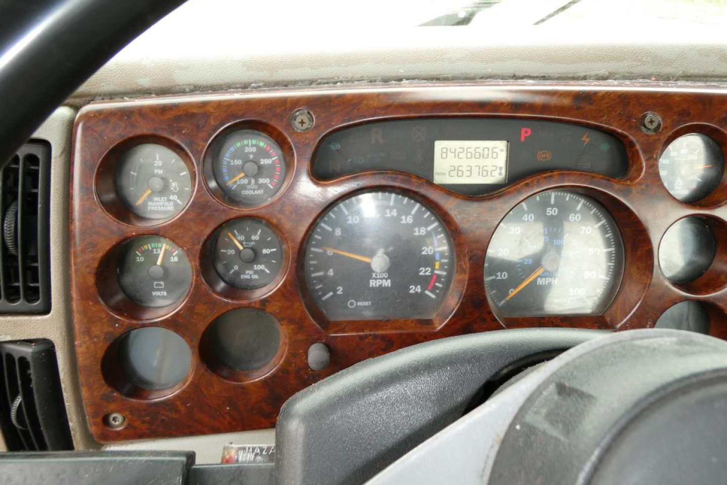 Dashboard of a 2006 Mack CHN613 showing instrument cluster with gauges and digital odometer. Text visible includes '8426606' and '063762' on the digital readout, various gauge labels around, and a woodgrain panel.
