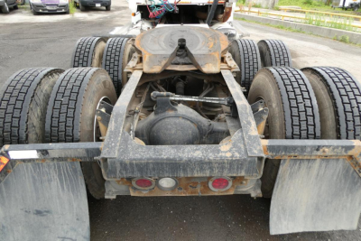 Rear view of a Mack CHN613 truck chassis showing dual rear axles, mud flaps, and hitch with rust-free rails; visible tires and frame components.