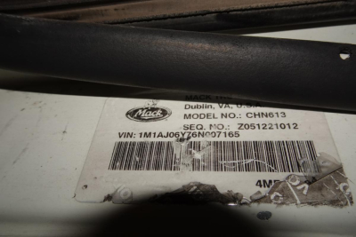 Mack CHN613 label with VIN 1M1AJ06Y76N007165 and barcode on white tag, under a black bar.