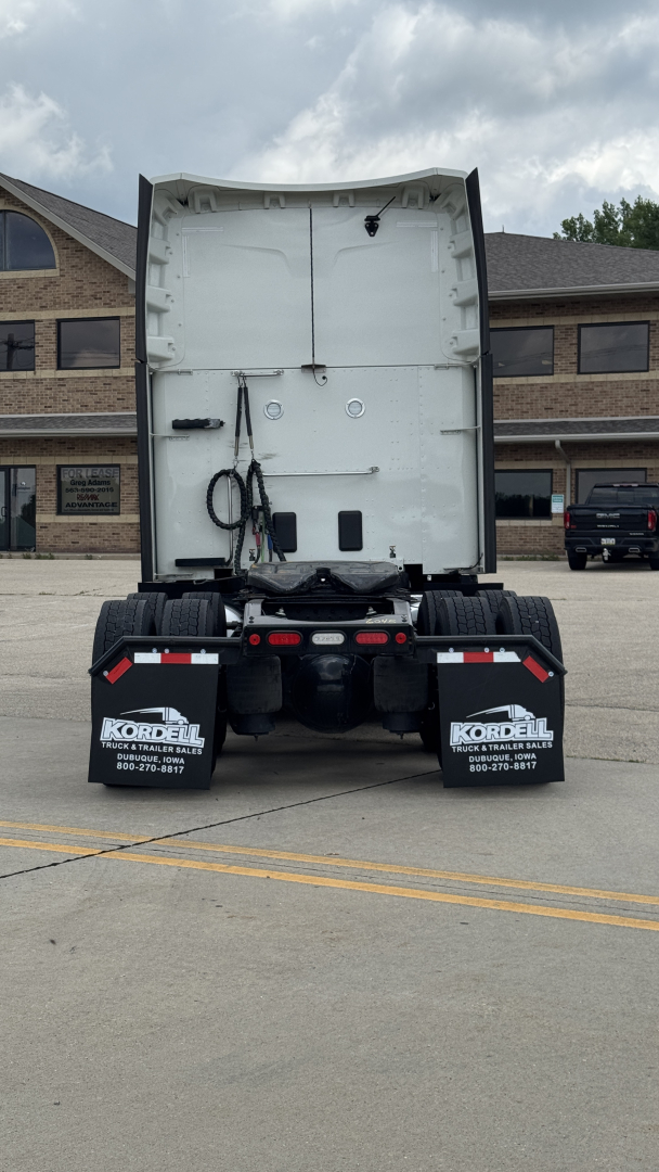 Peterbilt 579 rear view showing cabless tractor chassis with white cab back, black rear mudflaps, and fuel lines; no engine bay visible.