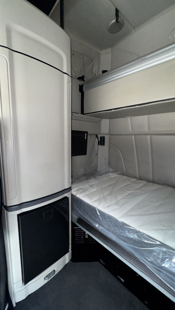 Peterbilt 579 sleeper cab interior showing bunk bed and storage cabinets.