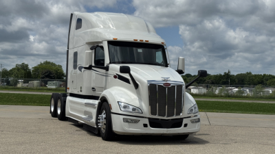 Peterbilt 579 tractor-trailer in white, front view, no cab details visible, two side mirrors, grille and headlights.