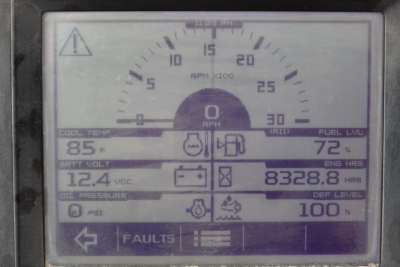 Instrument panel showing RPM gauge with digital readouts: coolant temp 85°F, charge volt 12.4 VDC, fuel level 72%, engine hours 8328.8, DEF level 100%. Left side shows faults button and icons.