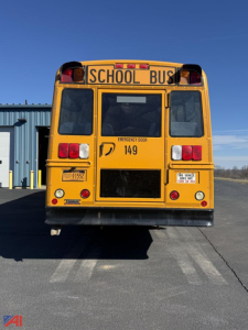 Rear view of a yellow school bus with 'SCHOOL BUS' sign, emergency exit door, tail lights, and number 149.