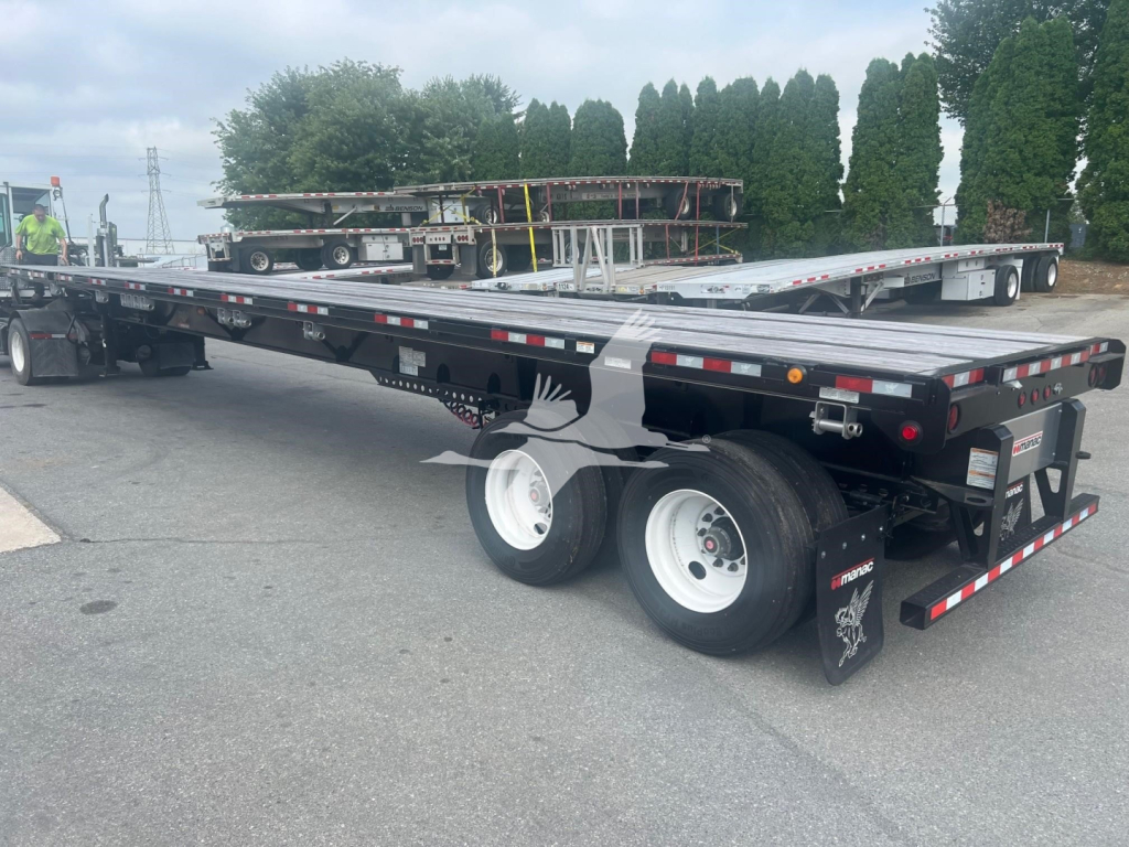 Manac extendable flatbed trailer with air ride suspension and dual rear axles, rear view showing taillights, mud flaps, and reflective tape.