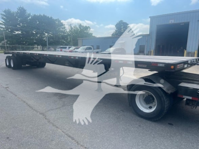 Manac air ride extendable flatbed trailer in a side view showing long aluminum deck, rear dual axles, and wheel/tire assemblies.
