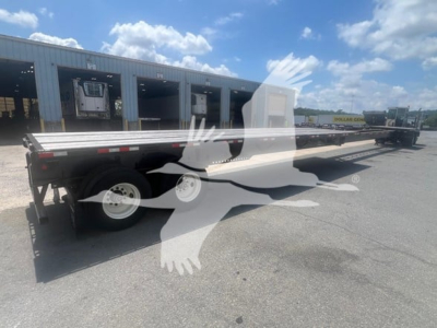 Manac air ride extendable flatbed trailer parked outdoors showing extendable deck and dual rear axles.