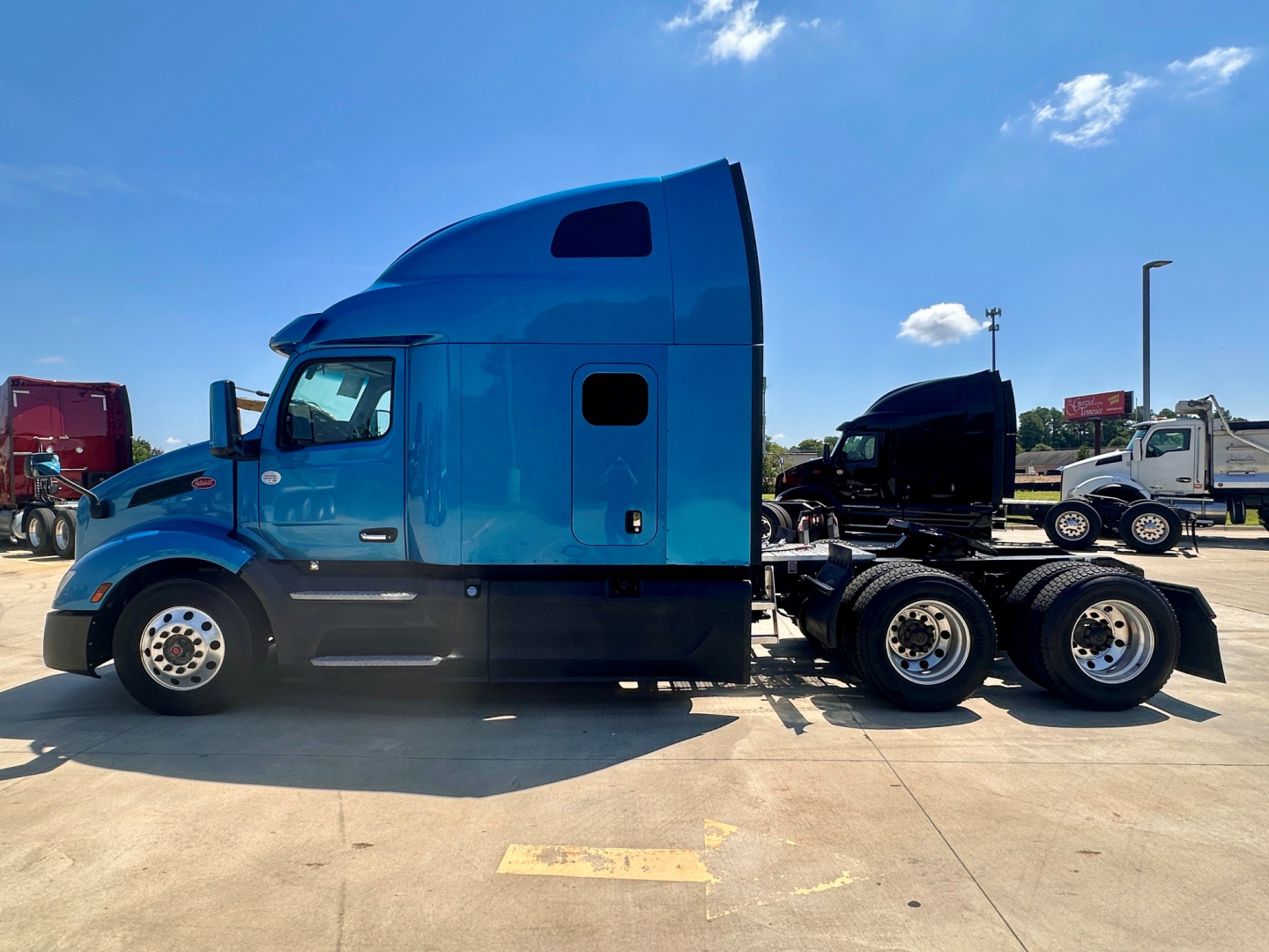 Peterbilt 579 truck in blue sleeper cab side profile showing side door, windows, and dual rear axles with fifth wheel.