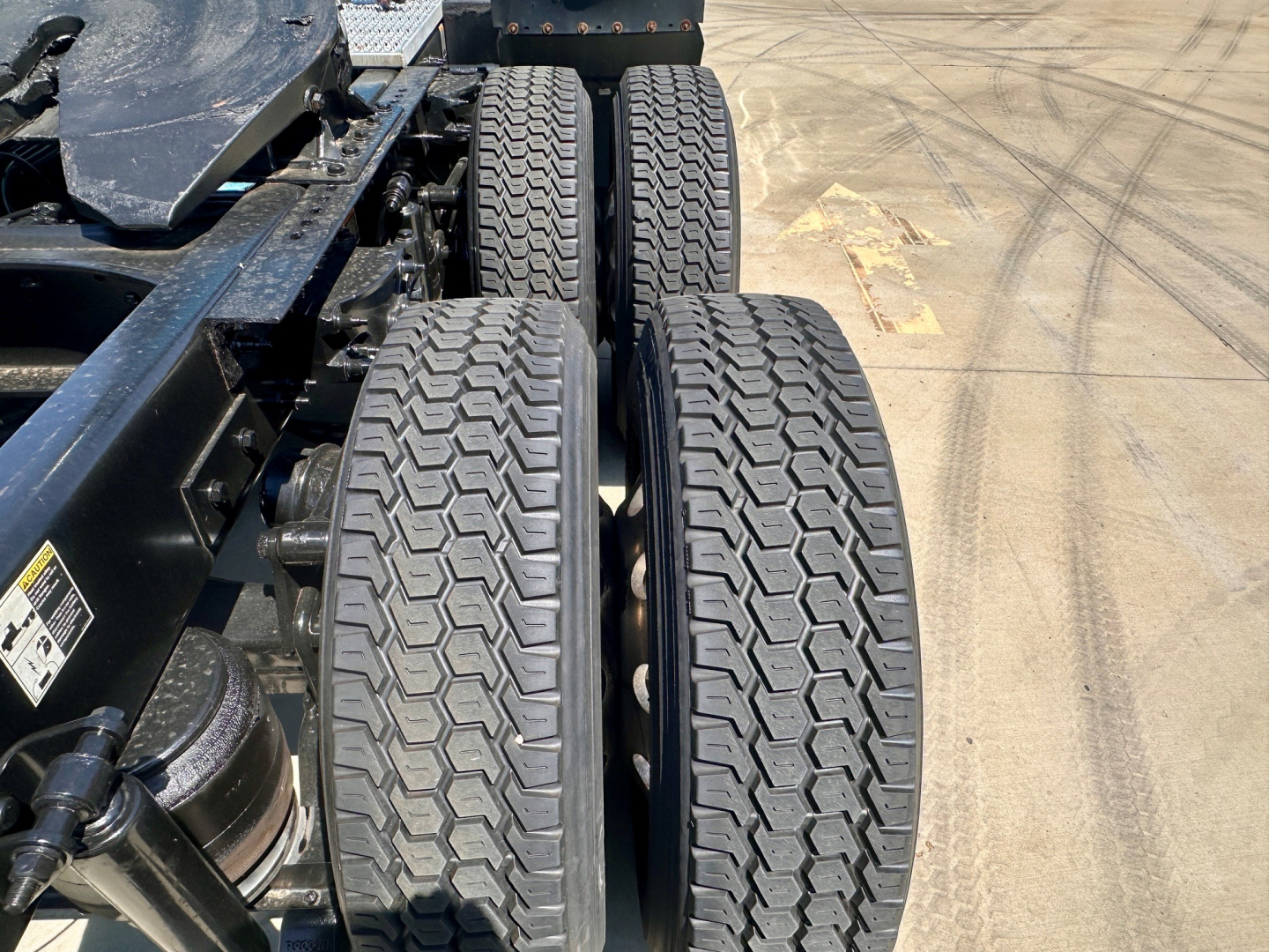 Peterbilt 579 chassis showing twin rear axles with treaded tires and suspension components visible.