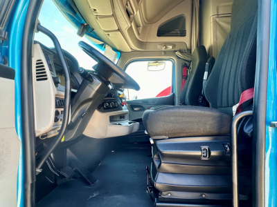 Peterbilt 579 cab interior showing driver seat with steering wheel and dashboard controls.