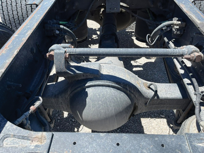 Rear axle housing and driveshaft underframe of a truck chassis showing differential housing and suspension components.