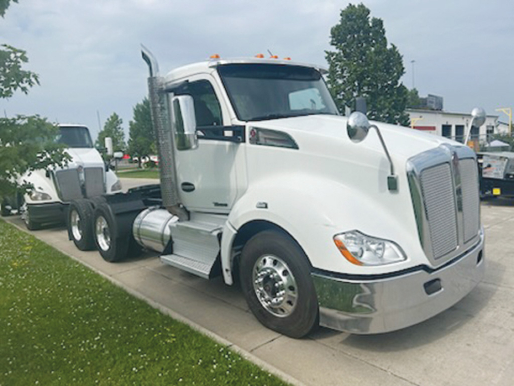 Kenworth T680 daycab truck in white with chrome bumper and sleeper-less cab, side view showing fuel tanks and dual rear axles.
