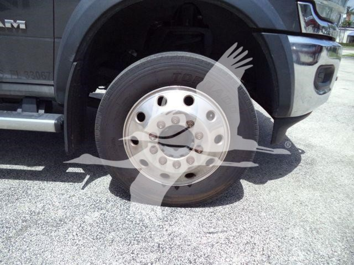 Ram 5500 front wheel and fender view showing alloy wheel and tire on rollback truck with Ram badge font.