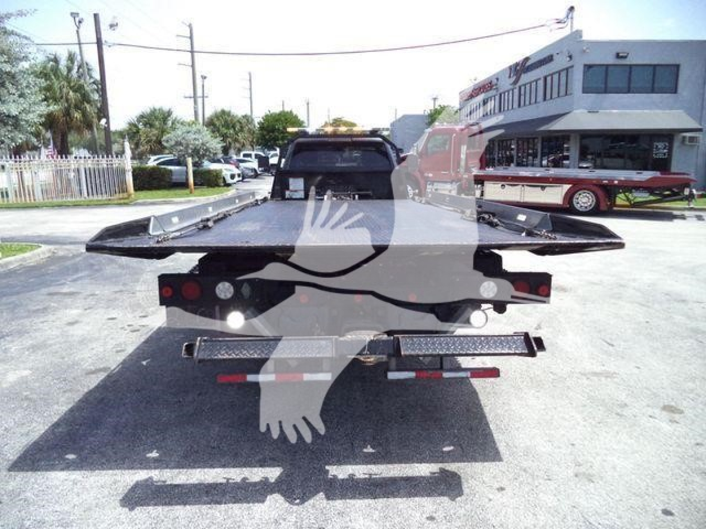 Truck bed of a Ram 5500 rollback showing dual rear ramps and towing equipment, rear view