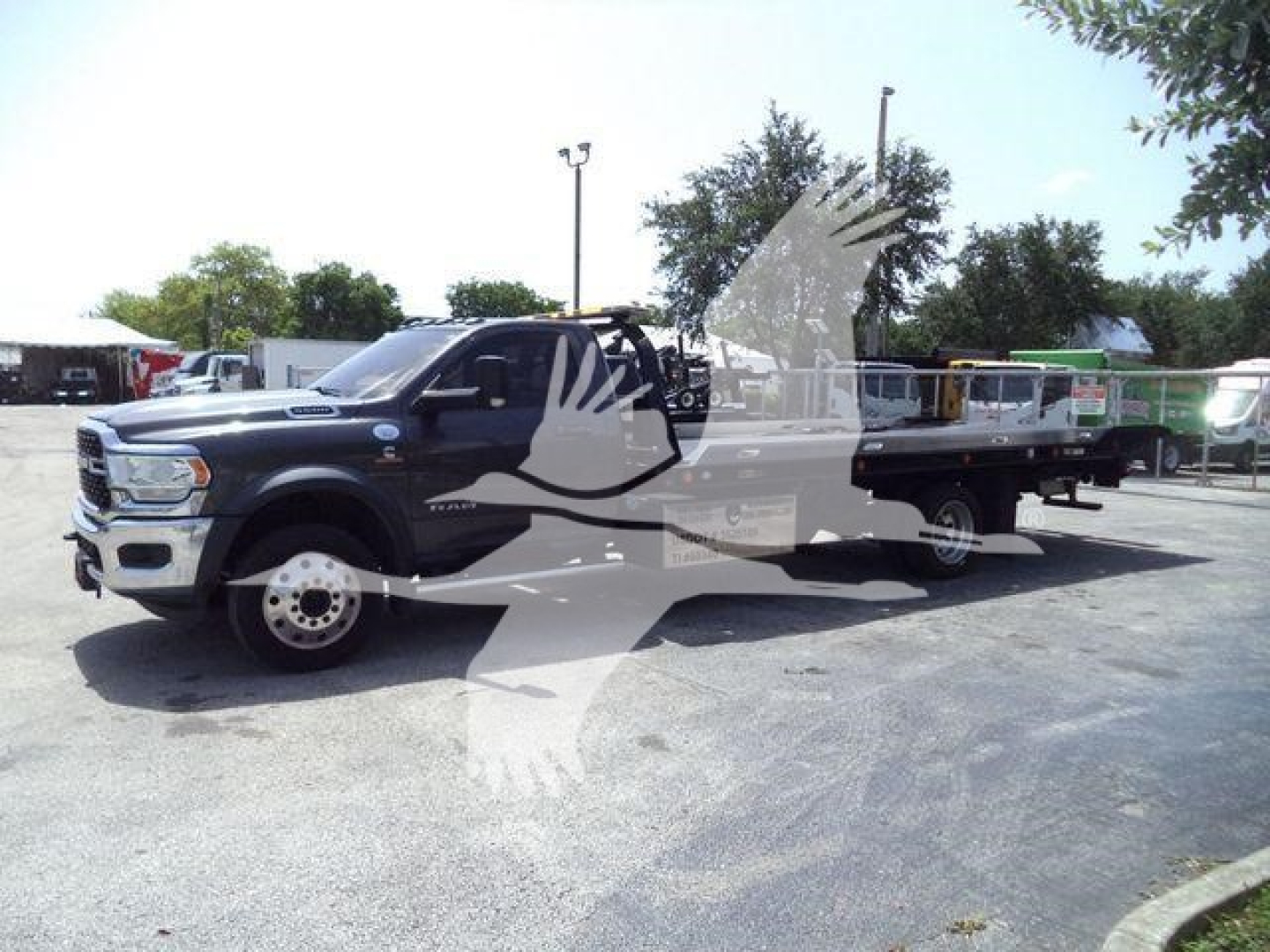 Ram 5500 rollback tow truck in blue showing cab and flatbed with watermark across image